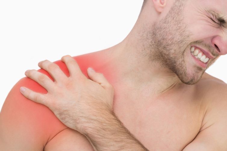 Closeup of young shirtless man with shoulder pain over white bac